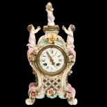 An ornate French 19th century porcelain-cased balloon mantel clock, surmounted by figures of
