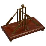 A late 19th century cricket themed letter stand, brass stumps and bats on mahogany base with brass