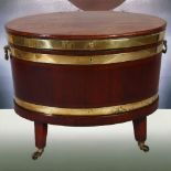 A George IV mahogany oval wine cooler with brass banding and fittings on stand, height 57cm, width