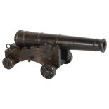 A patinated bronze table cannon, on wheeled steel carriage base, overall length 19cm