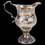 A George III silver helmet cream jug, Thomas Shepherd, London 1771, relief embossed floral