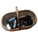 A wicker basket containing a quantity of designer sunglasses, various brand names including Hugo