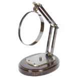 A large reproduction magnifying lens on wooden base, label reads "Watts & Sons Ltd, Opticians,