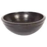 A 20th century turned wood fruit bowl of irregular shape, with ribbed decoration, maximum diameter