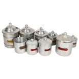 A graduated set of 4 French aluminium storage jars and covers with brass plaques, a similar set of