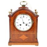 An Edwardian mahogany and satinwood-banded arch-top mantel clock, white enamel dial with Roman