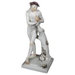 A Continental porcelain sculpture of a young nude man leaning against a tree, height 34.5cm, with