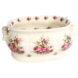 A cream ground ironstone 2-handled foot bath, with rose decoration, L44cm