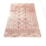 A salmon-ground Afghan rug. 150x105cm. Faded, fraying to edges. Small piece missing to one side.