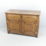 A panelled oak sideboard, with two frieze drawers and cupboards under. 117x83x49cm. With key. Top is