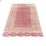 An antique red and blue ground Bokhara rug. 188x124cm Good condition. Fringes missing and some