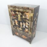 A Chinese black lacquered two-door cabinet, with painted, inlaid mother-of-pearl and applied