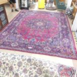 A red and blue-ground Keshan carpet. 395x314cm. Numerous signs of wear all over, moth damage, loss