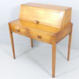 A mid-century teak writing desk, attributed to Reynolds of Ludlow, the raised compartment having a