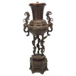 A Chinese bronze incense burner converted to a lamp, with cast scrolled handles, raised on hexagonal