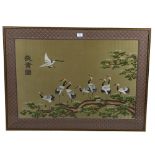 A Chinese silk embroidered picture, depicting storks on a branch, machine embroidered surround,