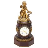 A French late 19th century mahogany and gilt-bronze mounted column-shaped mantel clock, surmounted
