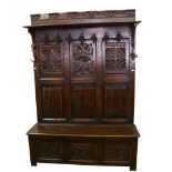 A 19th century carved oak, linenfold, high-back settle/hall-stand, with shelf over hooks and box