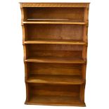 Gnomeman floor standing golden oak open bookcase, with relief carved frieze and shaped ends, width