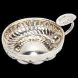A French silver wine taster, half fluted decoration, 2.1oz, diameter 8cm Good condition, monogram to