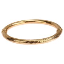A 9ct gold hinged bangle, ribbed and polished decoration, band width 6mm, internal circumference