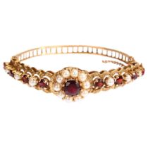 A mid-20th century 9ct gold garnet and pearl cluster hinge bangle, with central flowerhead cluster