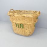 A vintage wicker basket, marked HM. 87x70x70cm.