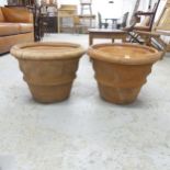 A pair of weathered terracotta planters with swag decoration. 46x36cm. One has been repaired.