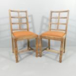 A pair of oak lattice back Cotswold school dining chairs in the manner of Heals.