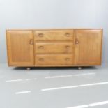 An Ercol mid-century Windsor 455 sideboard, with three drawers between two cupboards and blue