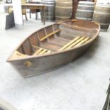 A mahogany two-section nesting dinghy. Overall 310x135x45cm, bow section 230x135x45cm. Appears in