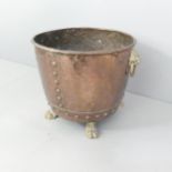 An antique copper planter / log bin, with brass lion mask handles and feet. 52x40cm.
