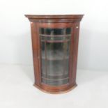 An antique mahogany bow front hanging corner cabinet. 69x98x52cm.