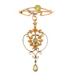 An Edwardian Art Nouveau 15ct gold peridot and diamond openwork drop brooch, set with pear and