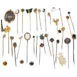 A collection of various unmarked gold and gilt-metal stickpins, including seed pearl and crescent