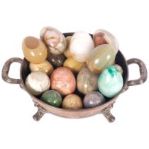 A collection of turned stone eggs, various sizes, in silver plated dish on claw feet
