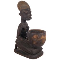 A carved stained wood African woman holding a bowl, H36cm