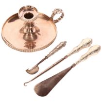 A silver-handled button hook, shoe horn, and another, and a silver plated chamber stick