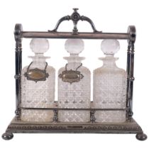 A set of 3 cut-glass decanters and stoppers, in silver plated tantalus stand, with 2 plated decanter