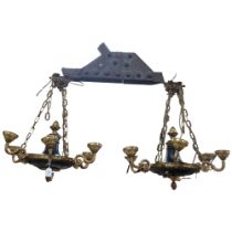 A pair of ornate cast-brass and black painted chandeliers, 65cm across