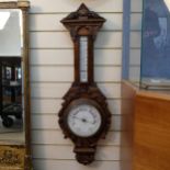 A lovely carved oak aneroid barometer, with mercury thermometer, length 95cm