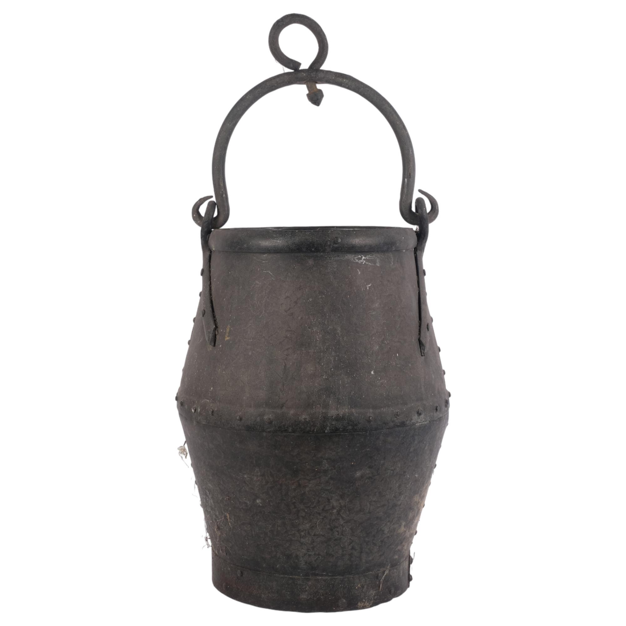 A cast-iron swing-handled cooking pot