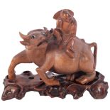 A carved hardwood water buffalo, surmounted by a figure, on carved and pierced fitted wooden