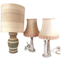 A pair of Spanish figure table lamps and shades, and an embossed pottery table lamp with shade