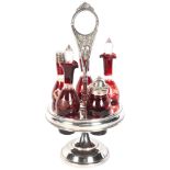 A silver plated revolving condiment stand, set with 5 engraved ruby red condiment bottles, with