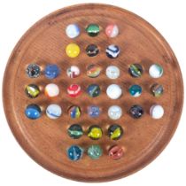 A turned wood solitaire board with Vintage marbles, 20cm