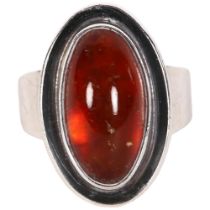 N E FROM - a Danish sterling silver and oval amber panel set ring