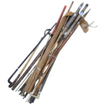 A collection of Vintage bamboo and other fishing rods, walking cane etc