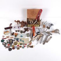 A collection of various bottle openers, corkscrews, whistle, brooches etc