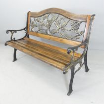 A pine slatted garden bench with cast iron ends and painted metal floral-design back panel.